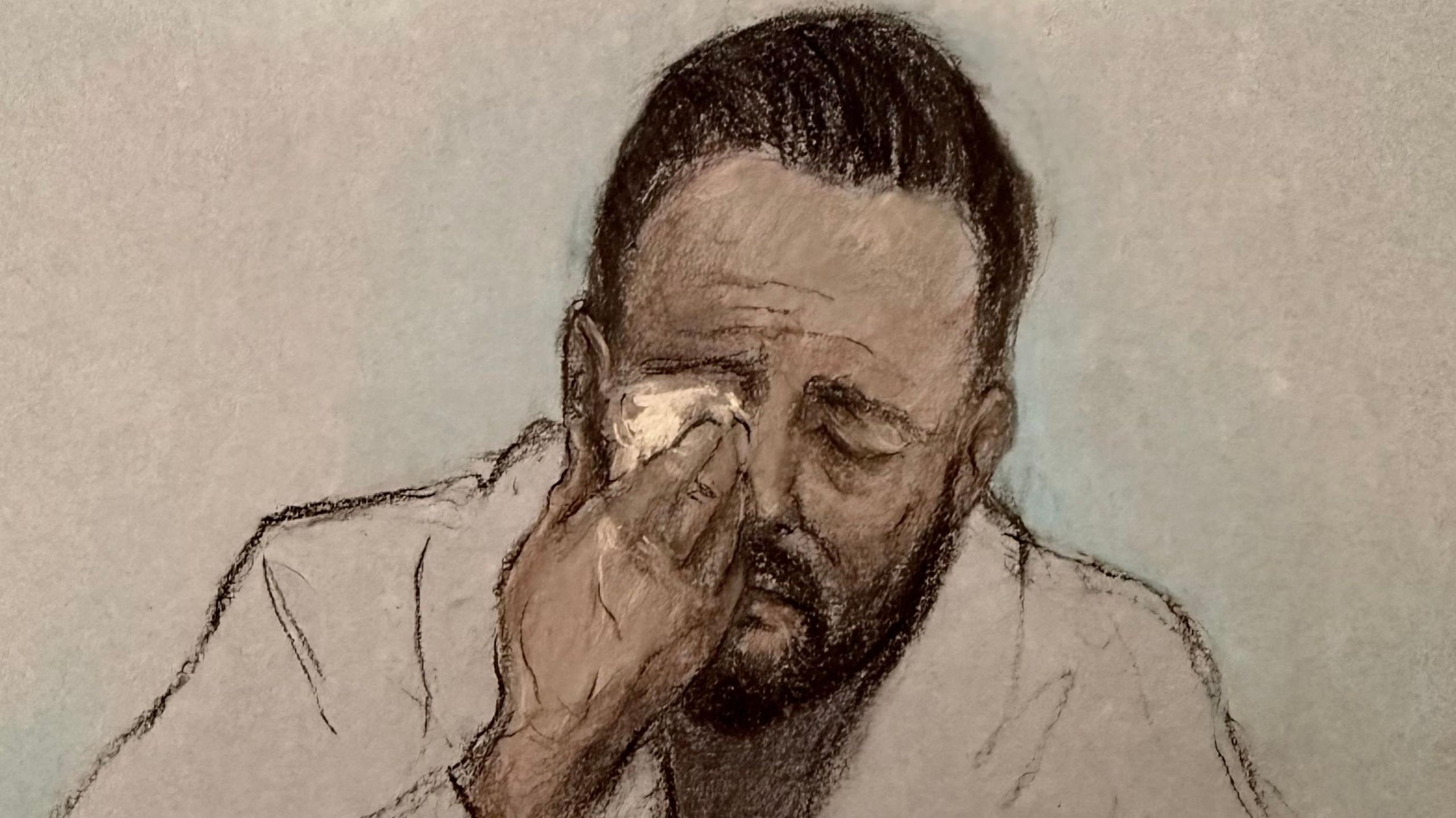 Court artist drawing by Elizabeth Cook of Daniel Thomas, also known as Danny Tommo, appearing via video link at Basingstoke Magistrates' Court, Hampshire, charged with criminal damage and failing to disclose the PIN to his phone, after he was filmed slashing a boat in the English Channel with a rescue crew member on board. He appears to be crying and is wiping his right eye with a tissue