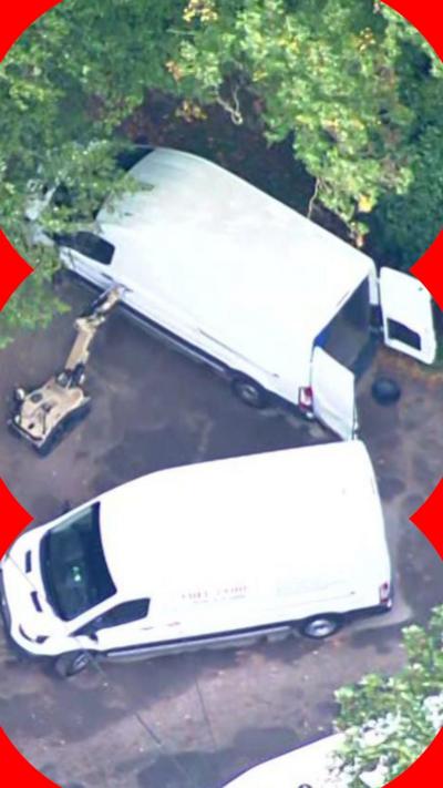 Aerial pictures showed a remote-controlled robot approaching stationary white vans in a wooded area