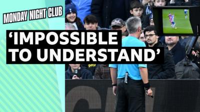 Referee Darren Bond checks the VAR screen before showing a red card 
