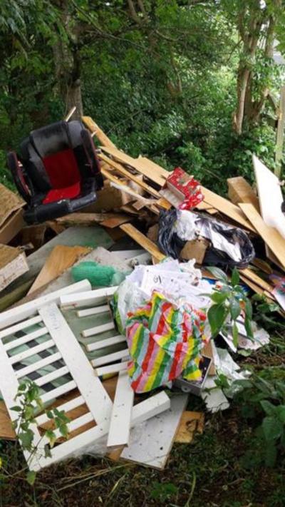 A pile of rubbish including household items like an office chair.