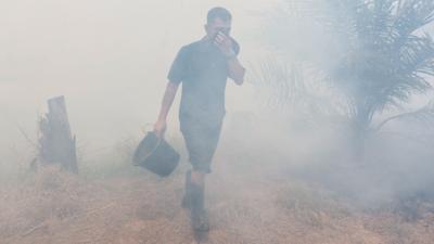 A man walking through smog in Indonesia