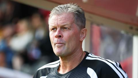 Steve Cotterill looks on towards the match action as he stands on the touchline during a match