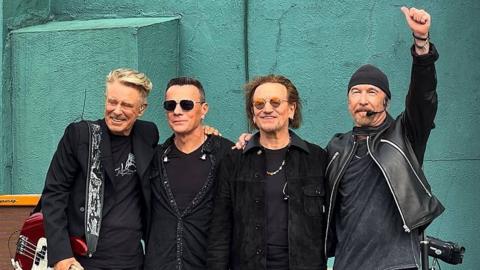 U2 on stage at their former school