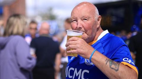An Everton fan drinks a beer before the Premier League match against Crystal Palace