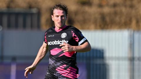 Kyle McAllister runs on the pitch during a match for Forest Green