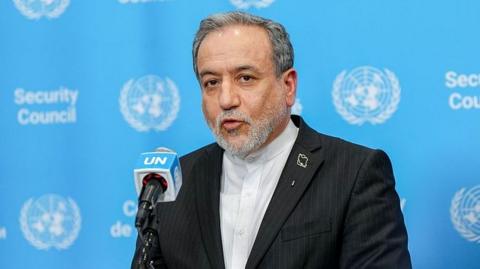 Iranian Foreign Minister Abbas Araghchi speaks in front of a podium against a blue UN background.