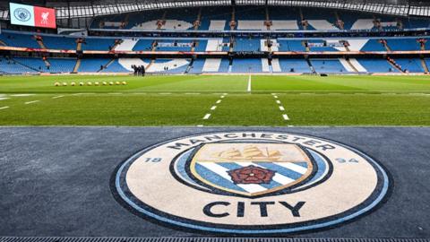 Manchester City sign with the stadium in the background.