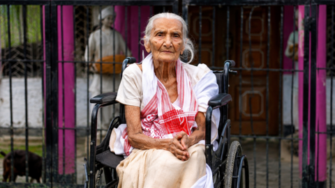 A 97-year-old Lokada Duarah was carried onto a banana tree trunk and taken to safety after floodwaters rose around her home