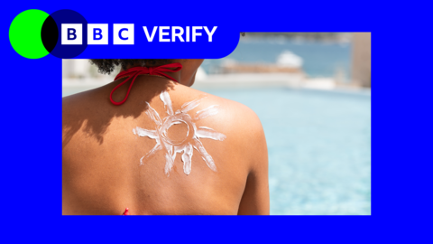 a woman's shoulder with sunscreen lotion on her back. she is outdoors next to a pool