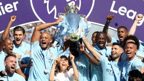 The team celebrating and holding the premiere league trophy in 2018