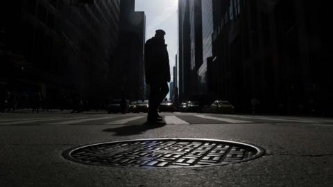 A photo of a manhole in New York City is shown