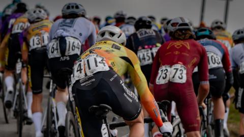 Picture taken from behind a pack of racing clycists