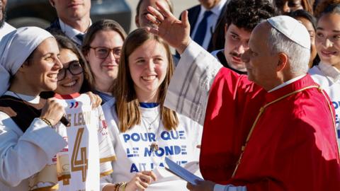 The Pope greets a crowd at the airport