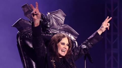 Ozzy Osbourne on stage sat in a black gothic throne