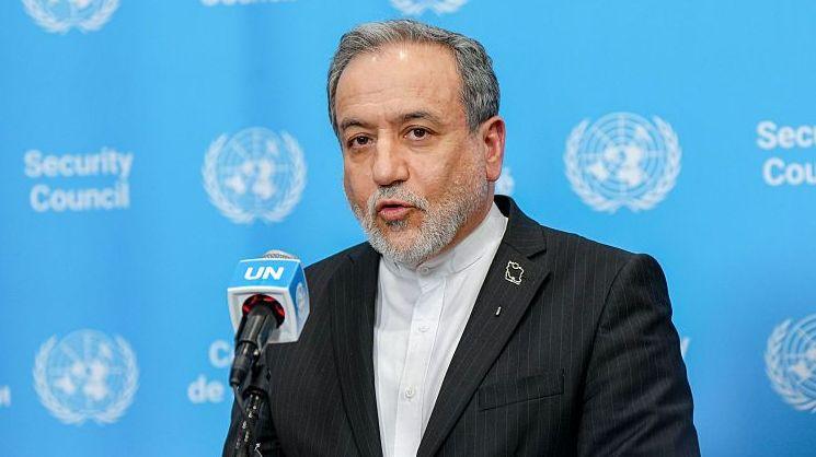 Iranian Foreign Minister Abbas Araghchi speaks in front of a podium against a blue UN background.