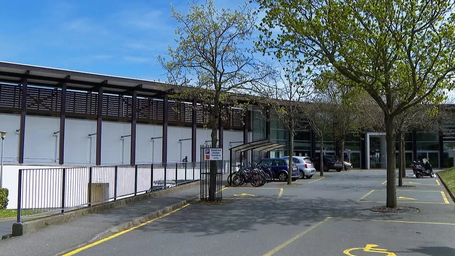 Cars and bicycles can be seen in the car park outside Beau Sejour.