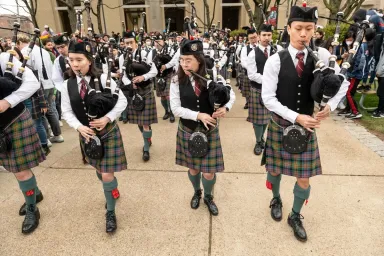 From left: Elizabeth Knox, Alexandra Knox and Roy Huang at the front of the CMU Pipes and Drums band at Spring Carnival opening on April 7, 2022. 