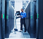 Man working on a laptop in a server room